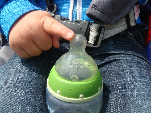 Baby finger on baby bottle